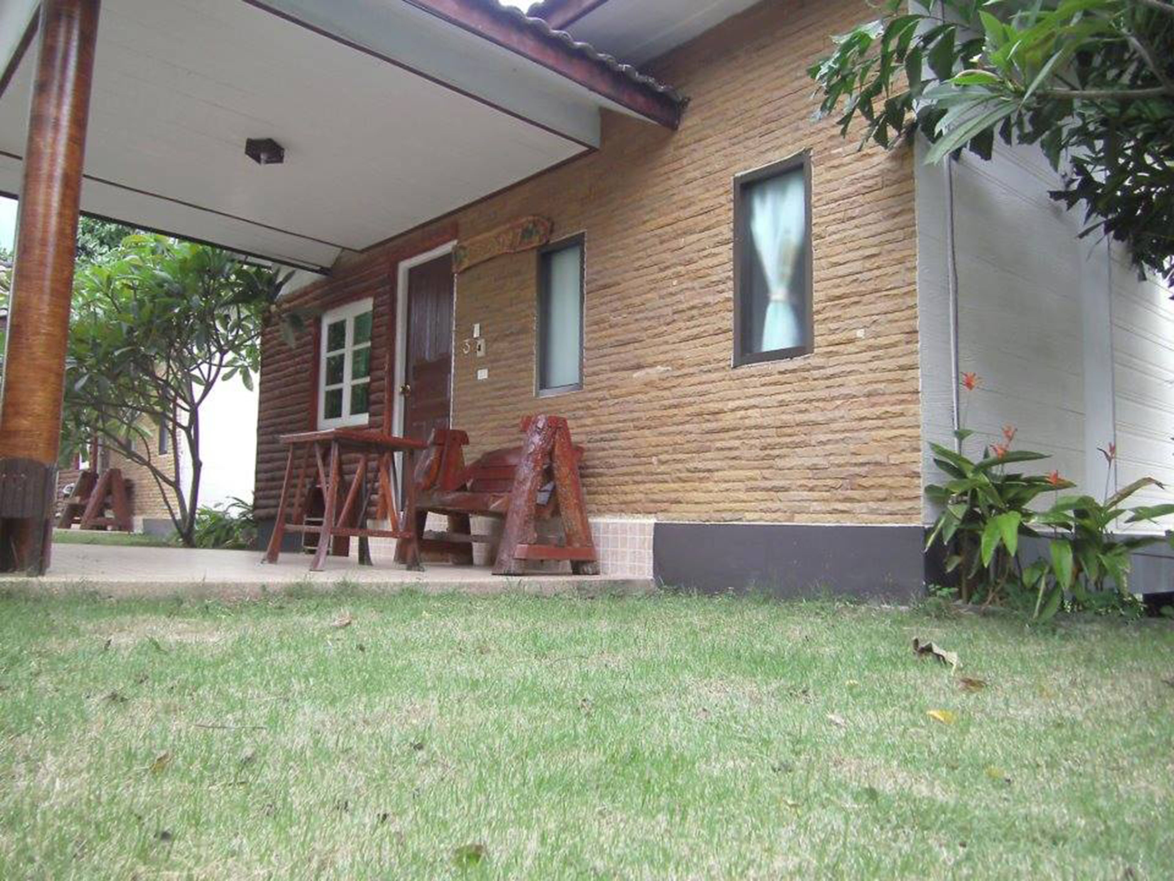 A wooden cabin with a porch, a window, and a door.