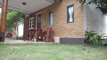 A wooden cabin with a porch, a window, and a door.