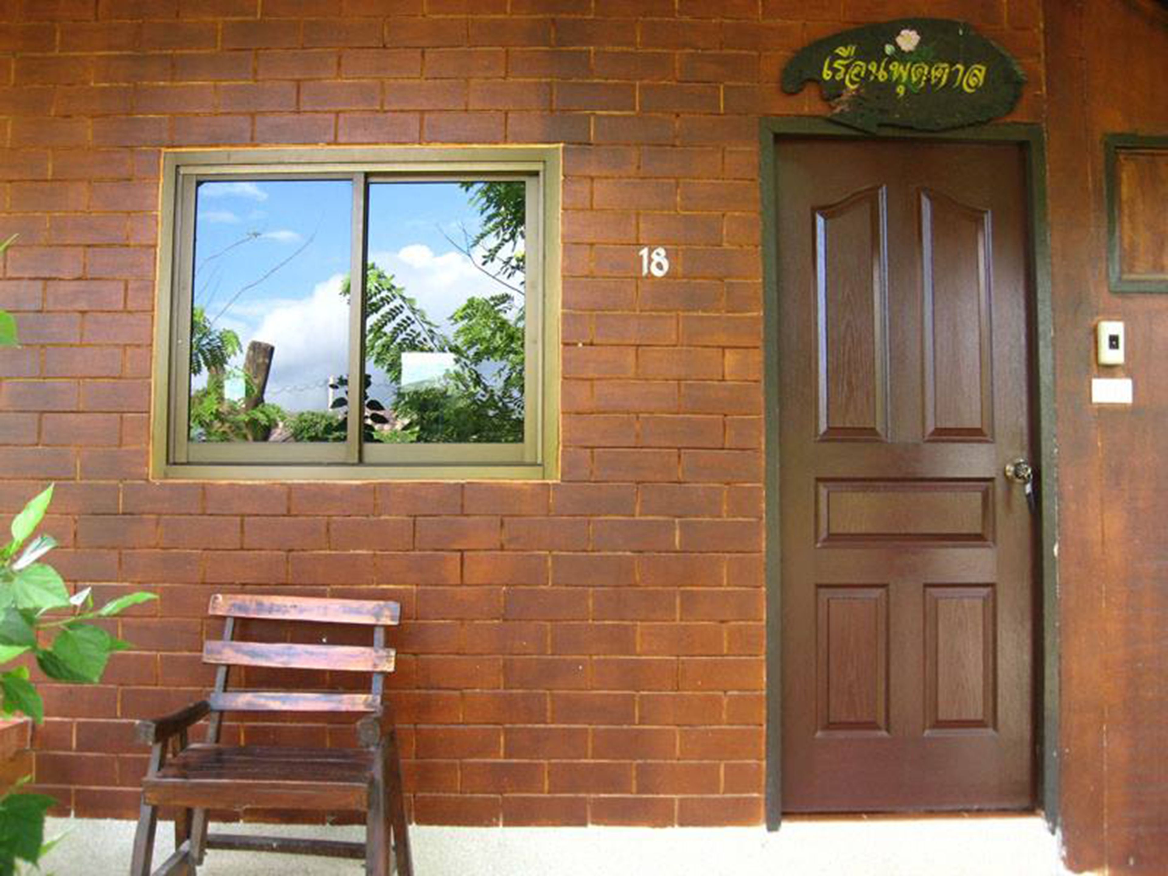 A brick building with a wooden door and a window.