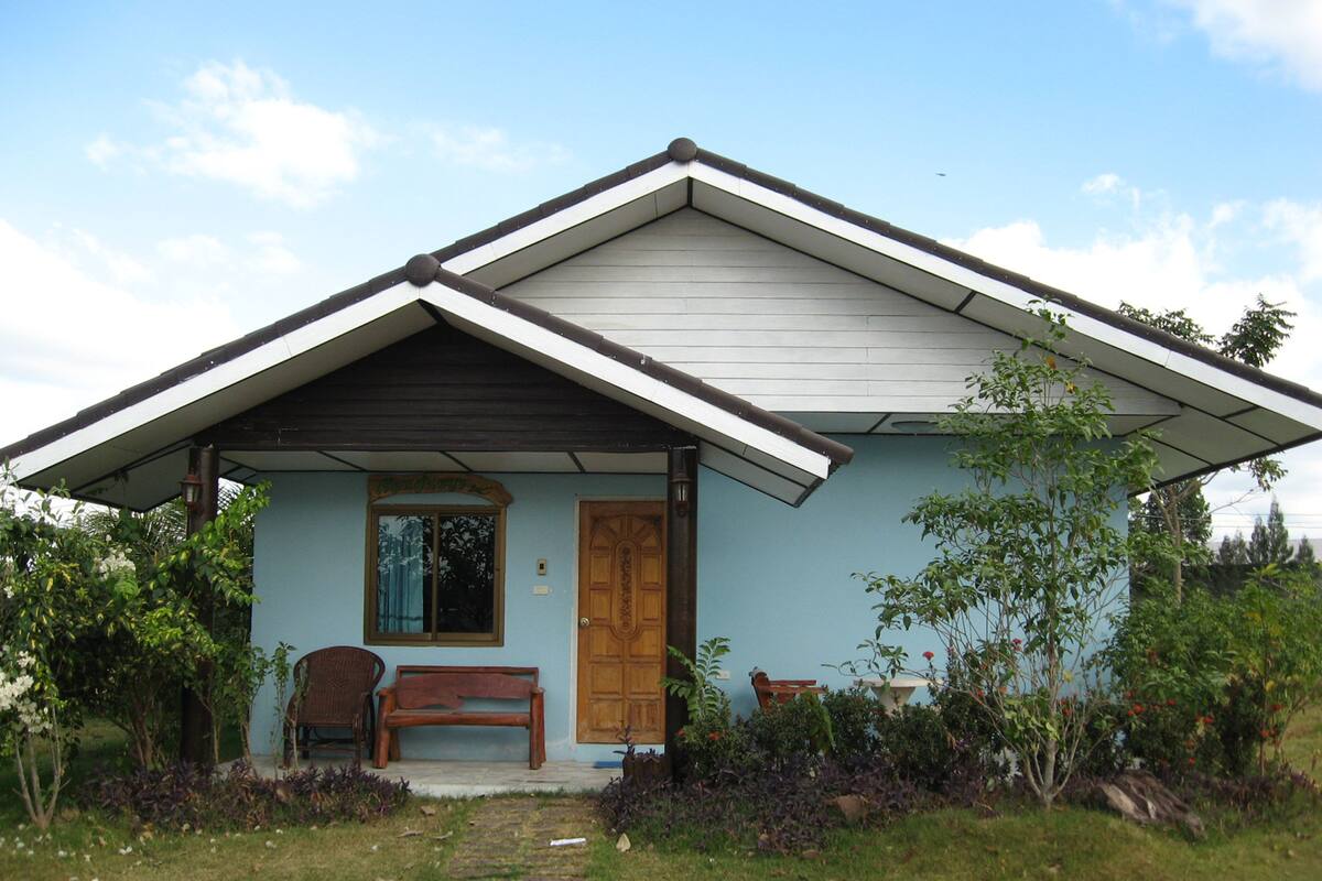 A small house with a porch, a wooden door, and a bench.