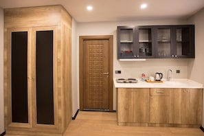 A modern kitchen with wooden cabinets, a double door wardrobe, and a built-in microwave. - Long Stay İstanbul (Taksim - Beyoglu - Istanbul)