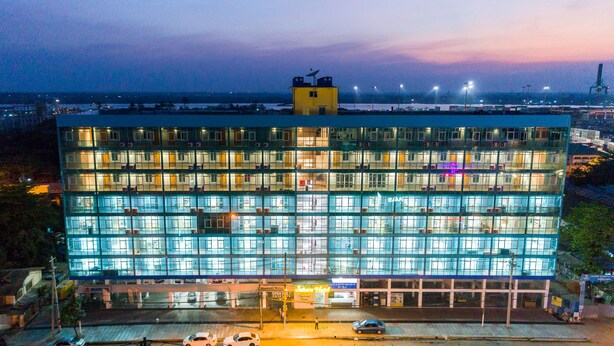 A multi-story hotel with a glass facade, multiple balconies, and a rooftop antenna. - Sakura Hotel (Yangon)