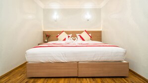 A modern hotel room with a wooden floor, a large bed with white bedding, and two wall-mounted lights. - Sakura Hotel (Yangon)