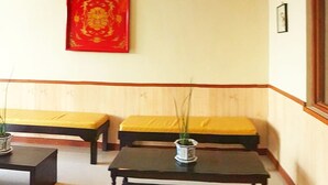 A room with two black tables, yellow cushioned benches, a red decorative piece on the wall, and a hanging light fixture. - Asiatel Hotel, Sta. Rosa, Laguna (Santa Rosa)