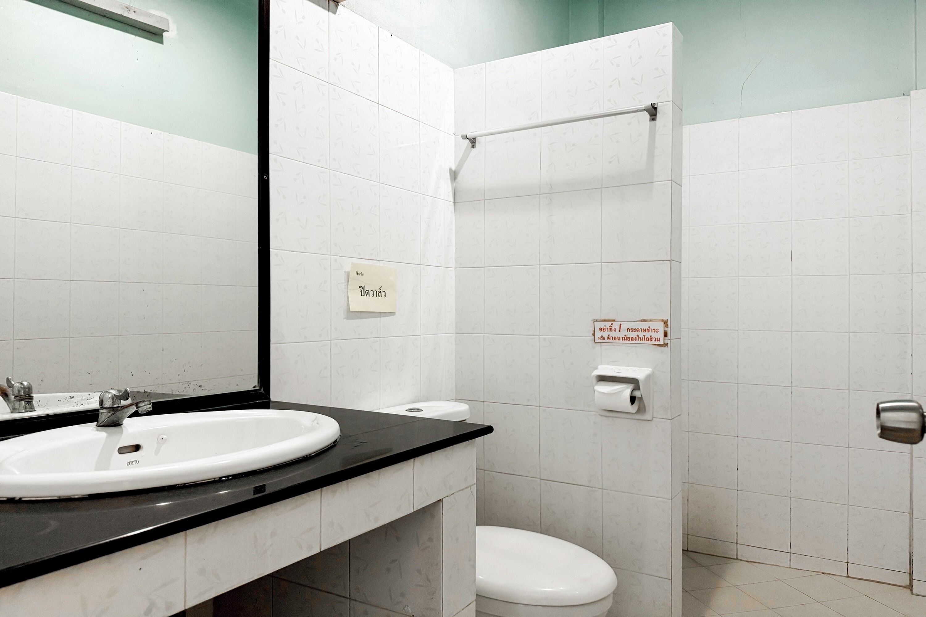 A bathroom with a white sink, toilet, and shower.