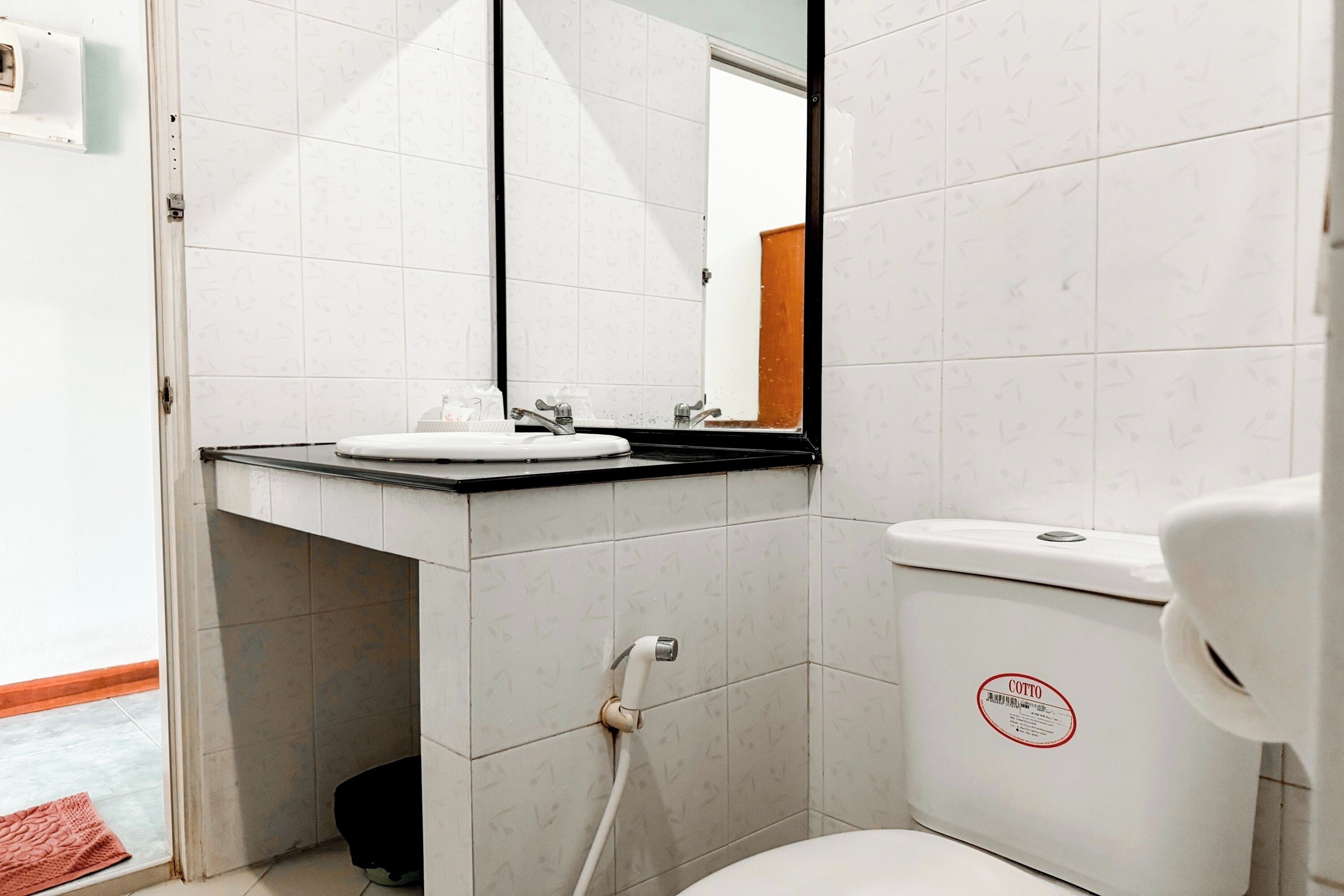 Un bany amb vàter, un lavabo i un mirall.