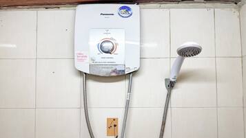 Ducha eléctrica Panasonic montada en la pared, con panel de control, dos mangueras flexibles y un cabezal de ducha.