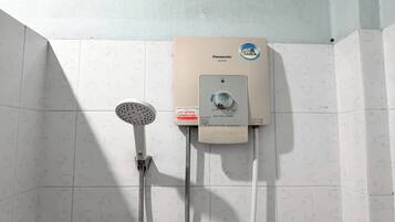 Un baño con ducha eléctrica Panasonic instalada en una pared con azulejos.