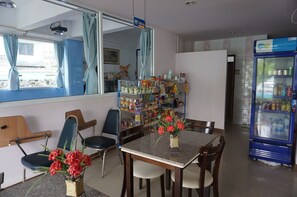 Une chambre d’hôtel avec un coin repas, un distributeur automatique et une vue sur l’extérieur.