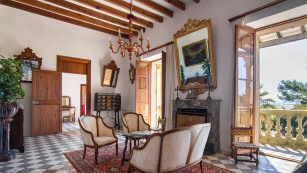 A room with a checkered floor, wooden furniture, a chandelier, and a large mirror. - Son Sant Andreu (Petra)