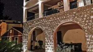 Un edificio a più piani con facciata in pietra, portali ad arco e balconi.