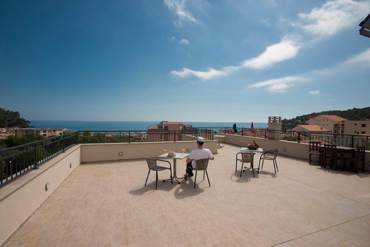 Une terrasse avec une table et des chaises, offrant une vue sur la côte.