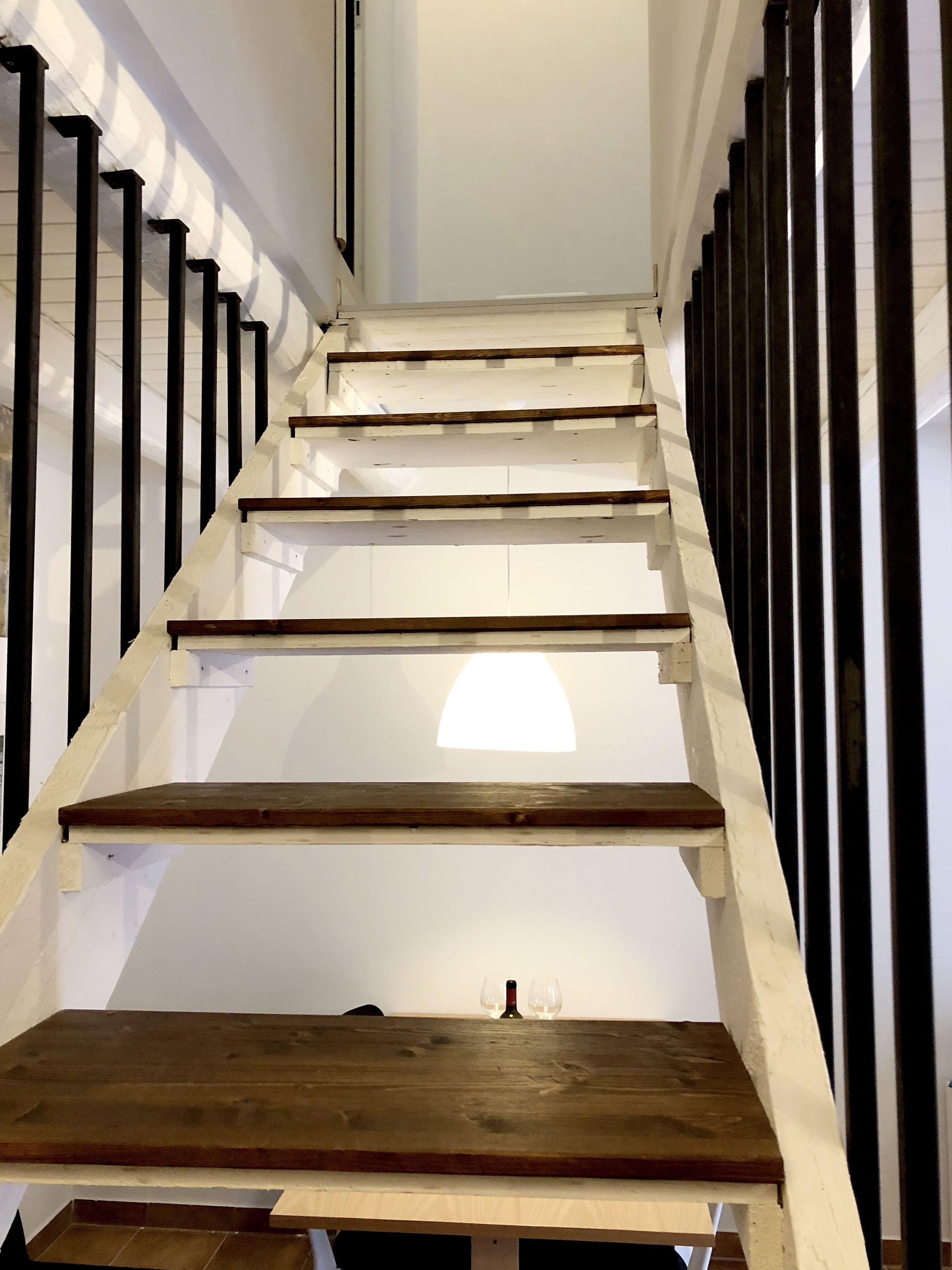 A staircase with wooden steps and black balusters.