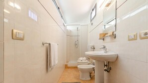 Ein modernes Badezimmer mit Dusche, Toilette, Bidet und Waschbecken.