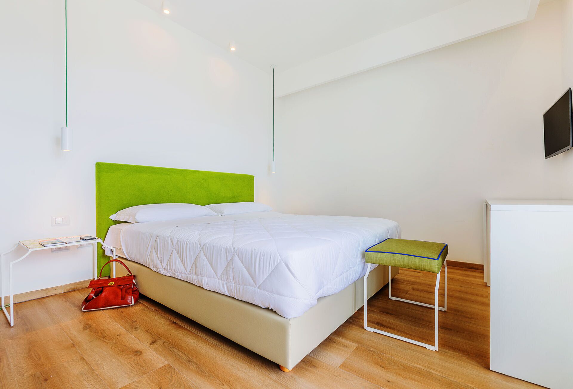 Une chambre à coucher comprenant un lit, une table de chevet, une lampe et un couvre-lit.
