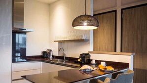 Una cocina moderna con una isla central, una cafetera y un lámpara colgante.