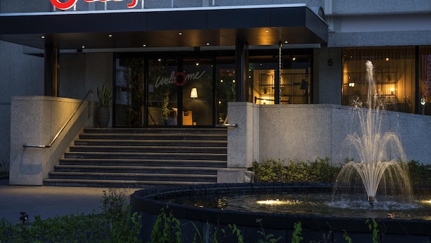 Een Adagio aparthotel met een gastvrije entree, een fontein en een trap naar de deur.