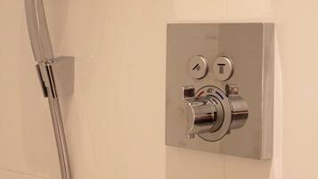 A modern shower control panel with a handheld showerhead.