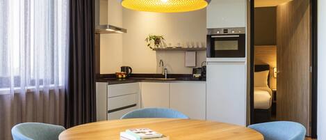 A modern kitchen with a built-in oven, a coffee machine, and a sink.