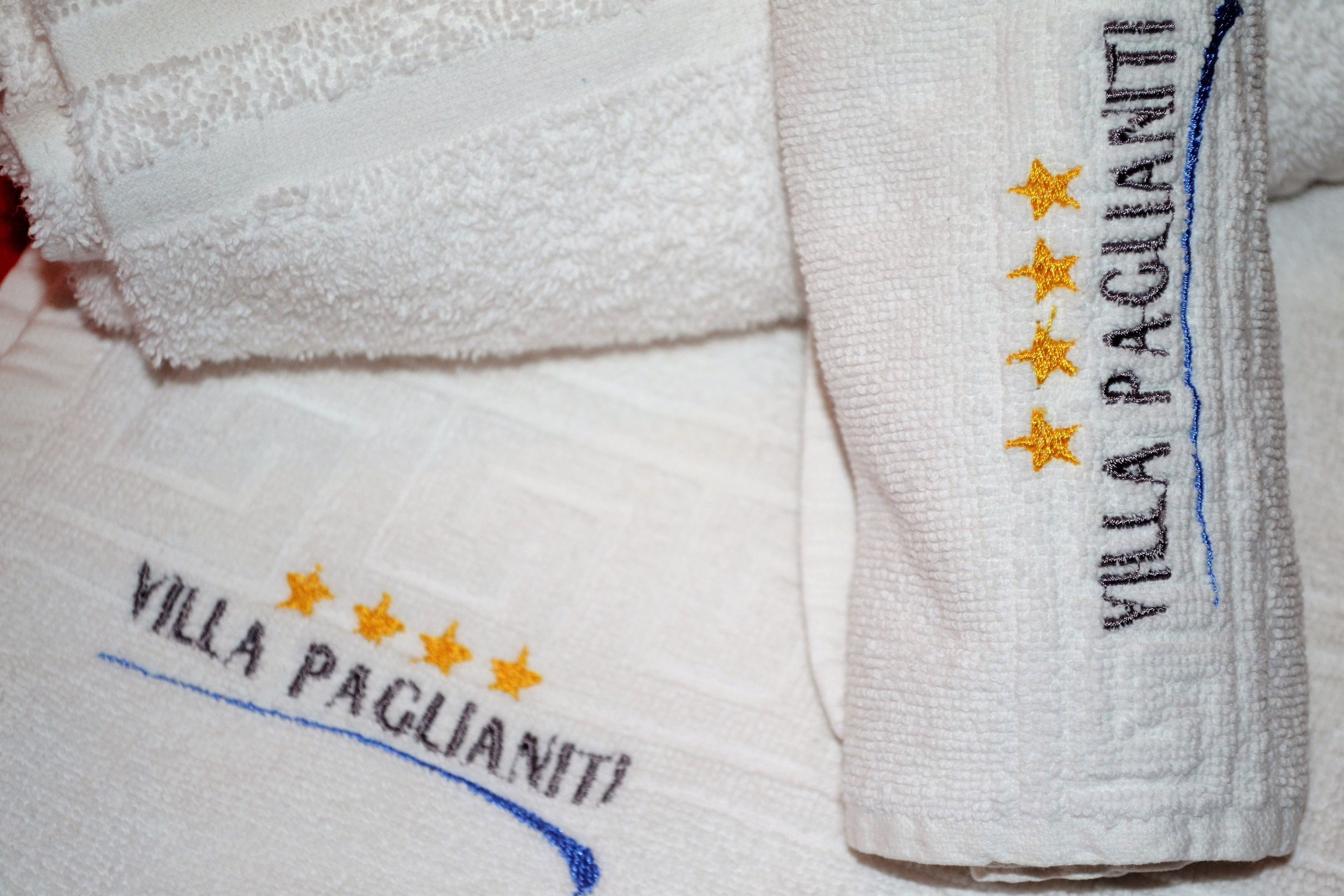 A set of white towels with embroidered text and stars.