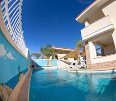 Una piscina al aire libre de temporada, sombrillas