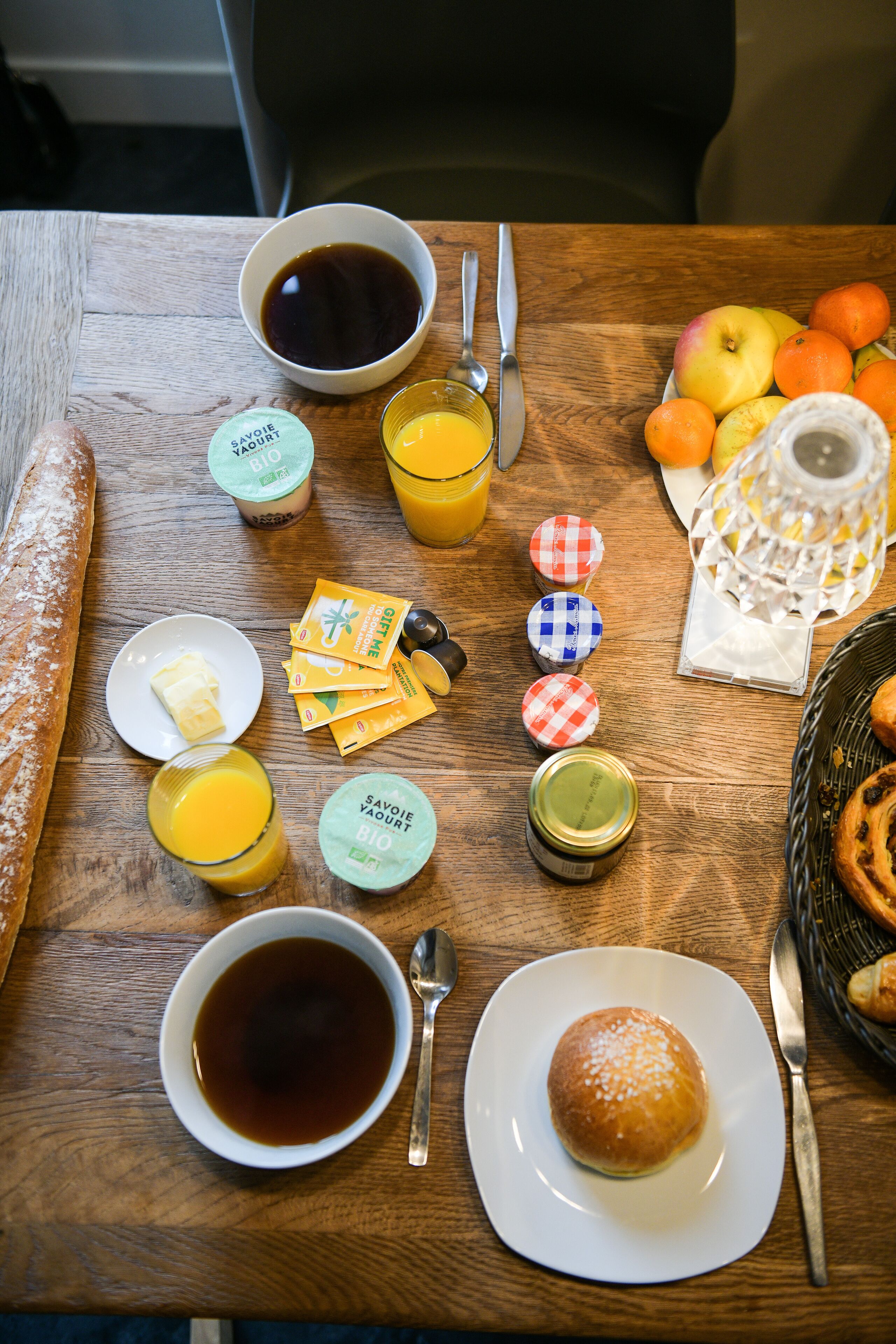 A breakfast table with various food items and condiments.
