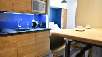 Une cuisine moderne avec des meubles en bois, un four à micro-ondes encastré et une machine à café.