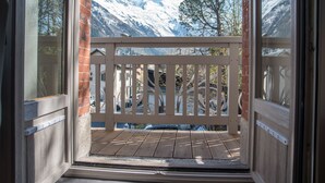 A balcony with a view of snow-covered mountains and trees. - Aiguille Verte & spa (Chamonix-Mont-Blanc)