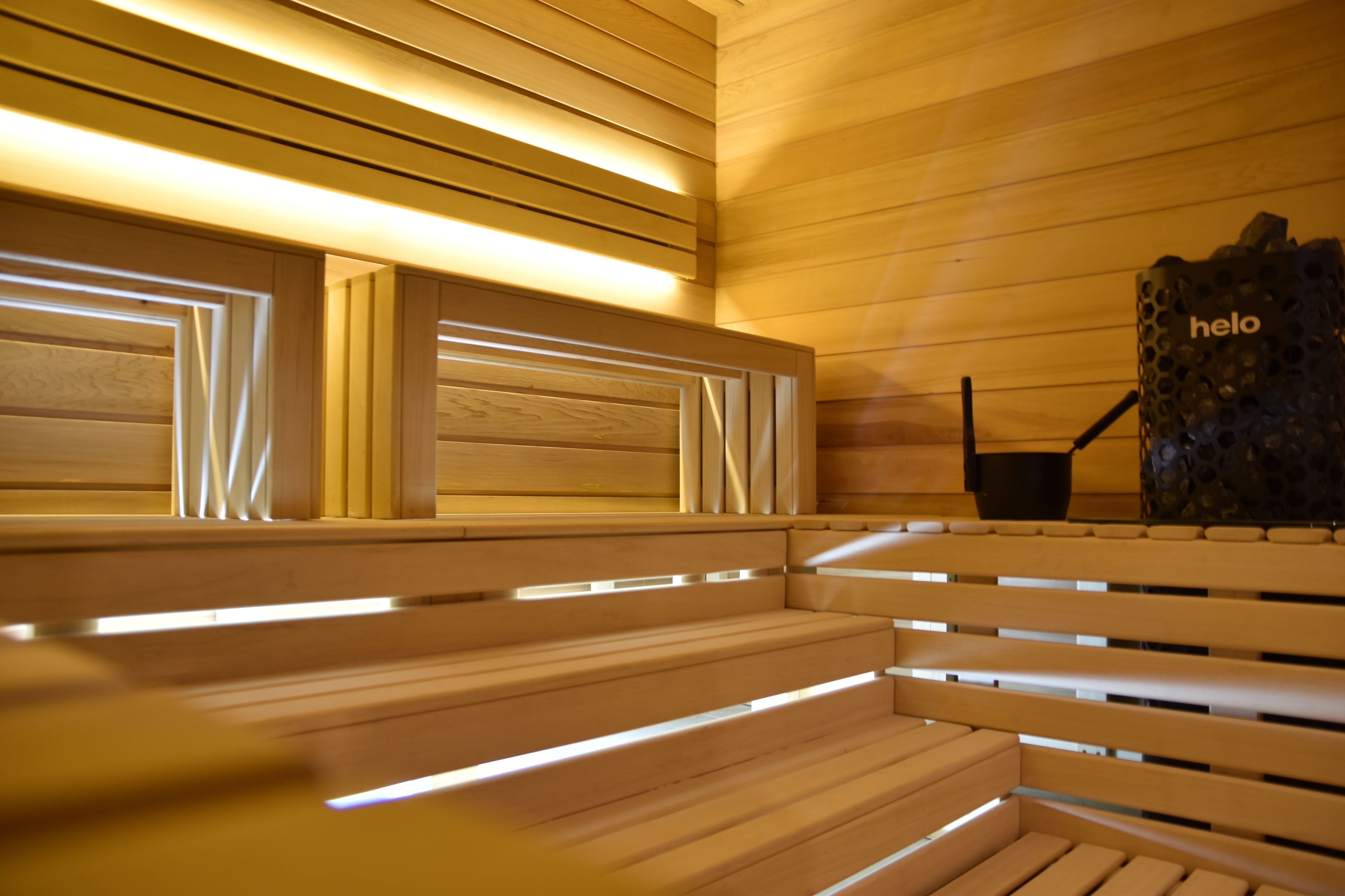 Un banco de madera con iluminación integrada, una pared de madera y una escultura con la palabra "helo".
