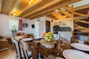 Un comedor con una mesa de madera dispuesta para una comida, rodeado de sillas.