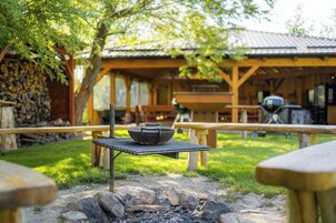 Un área de comedor al aire libre con una parrilla, una mesa con un bol y un hogar de piedra.