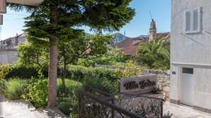 A villa named "Villa Lucca" with a stone wall, metal gate, and lush greenery. - Villa Lucica Trogir (Trogir)