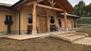 A Club House with a wooden facade, stone steps, and a tiled roof.