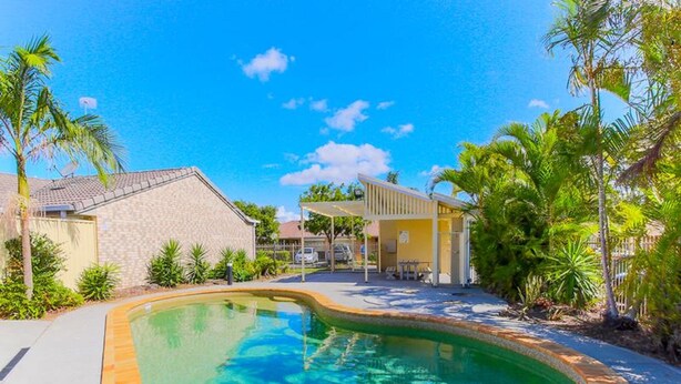 A residential area with a swimming pool, houses, and a covered patio. - Gold Coast Theme Park Villa (Coomera)