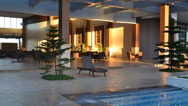 Ett rymligt inomhusområde med en pool, solstolar och sittgrupper.