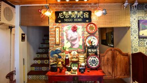A traditional Chinese home interior with a wooden ceiling, a sign reading "NEGO HOME", and various cultural artifacts displayed on a table. - Nego Home Ancient Hotel (Bangkok)