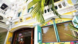 A colorful building with a floral mural, a shop entrance, and a visible sign. - Nego Home Ancient Hotel (Bangkok)
