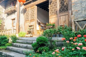 A traditional wooden building with a stone staircase leading to a wooden door. - Memory of Pan＇s (Guilin)
