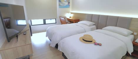 Una habitación de hotel con dos camas, un escritorio, un televisor y un cuadro en la pared.