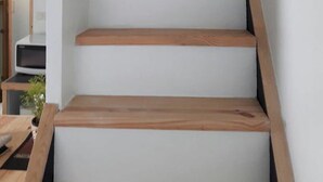 Een trap met houten treden en witte muren.