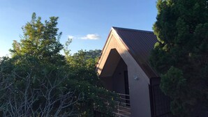 Un edificio con techo inclinado, rodeado de árboles.