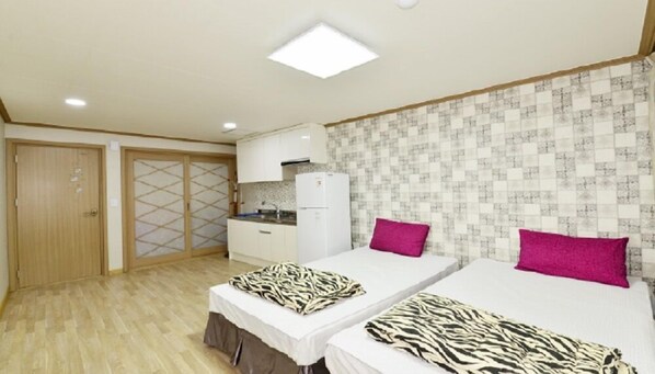 A hotel room with two beds, a kitchenette, and a sliding door closet. - Naksan Meriel Condo (Yangyang)