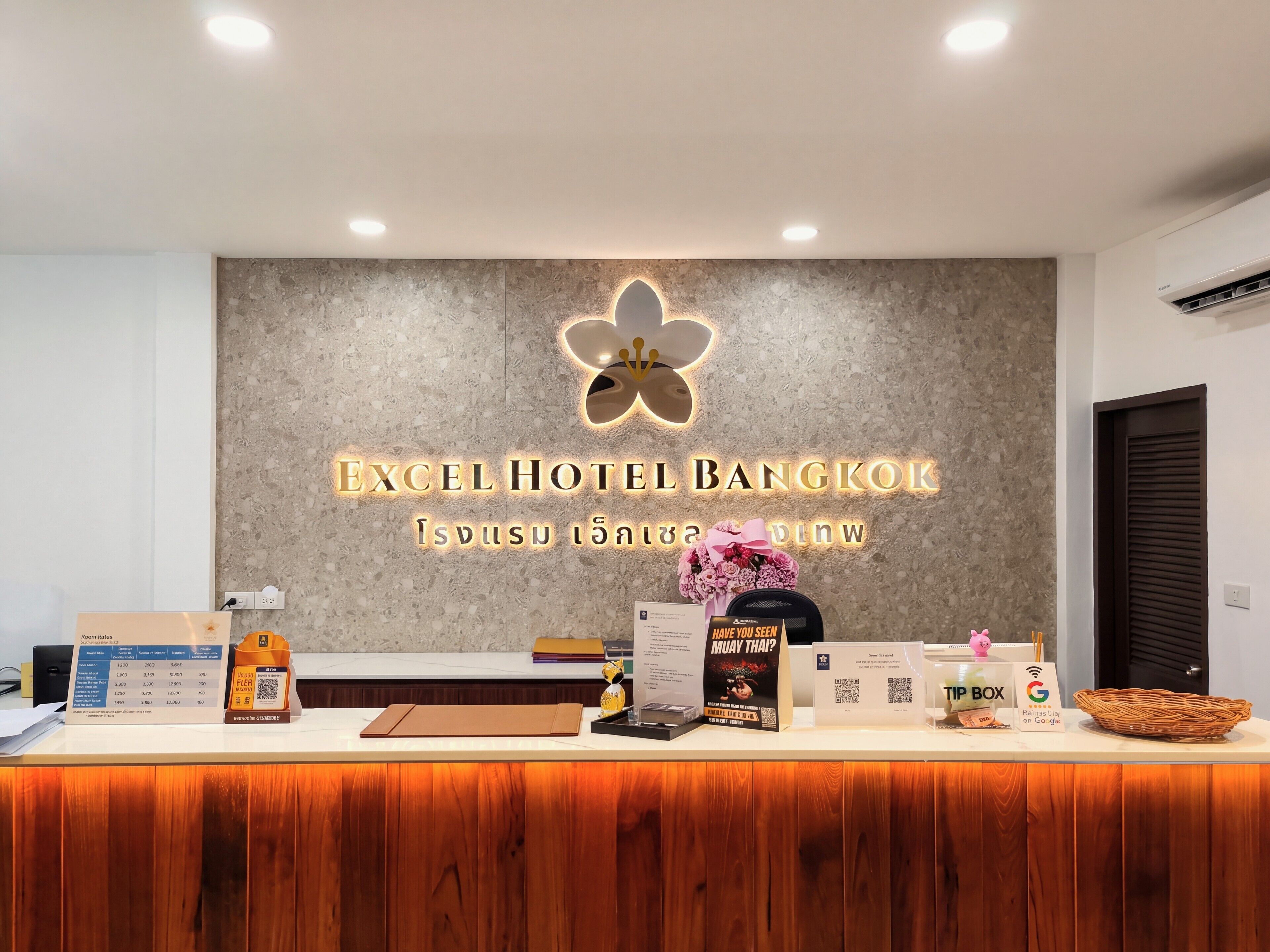 A hotel reception desk with a modern design, a logo, and various informational materials.