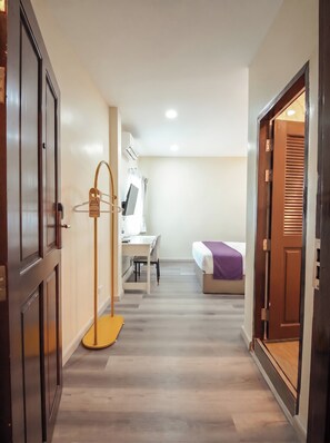 Une chambre d’hôtel comprenant un lit, une table de chevet et un bureau avec une chaise.