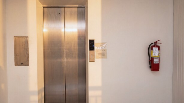 Een lift met een brandblusser aan de rechterwand bevestigd.