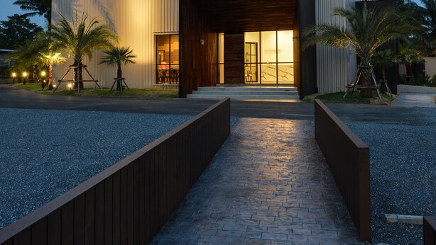 Een modern gebouw met een bord waarop 'The Chill' staat en een goed verlichte ingang.
