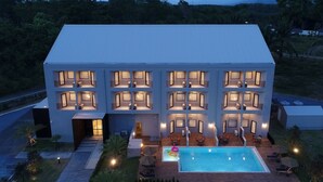 Een modern hotel met meerdere verdiepingen, een zwembad en terras.