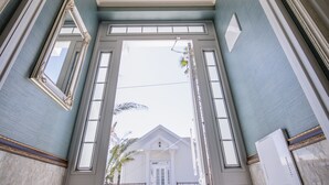 Una entrada imponente con una puerta blanca, un extintor y vistas de un edificio con escalones y una reja.