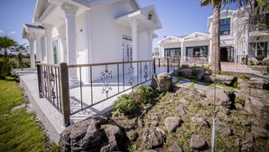 Un edificio blanco con columnas y una entrada portonada.