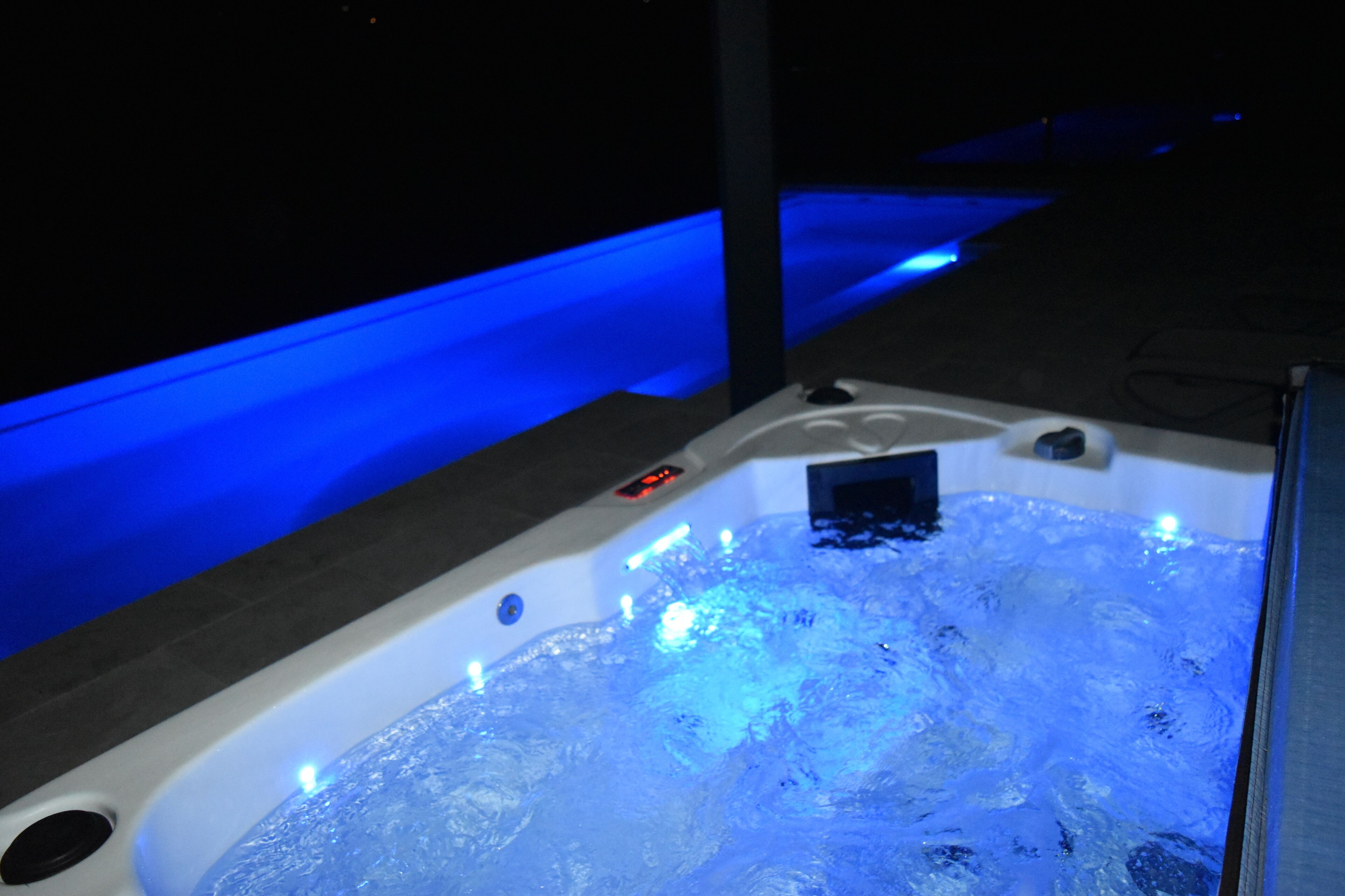 Un bain à remous doté d’un éclairage bleu, d’un panneau de commande et d’un écran numérique.